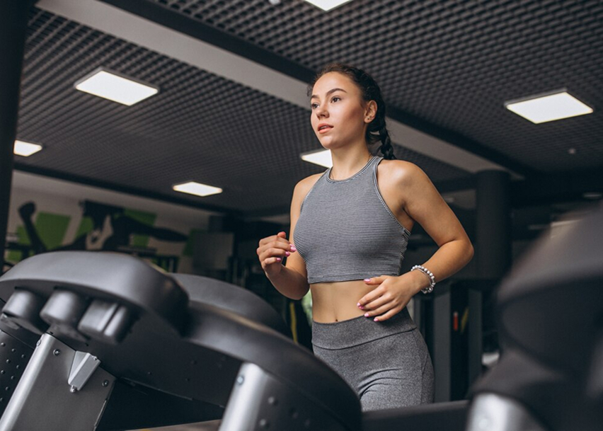 Девушка бежит на беговой дорожке